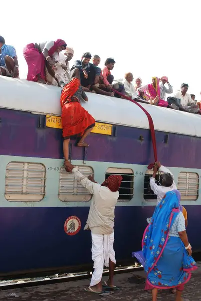 stock image Man helping woman trying to climb on roof of train on railway station, Jodhpur, Rajasthan, India 