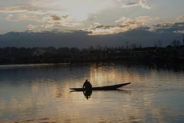 Günbatımında Dal Gölü 'nde Lone shikara; Srinagar; Jammu & Kashmir; Hindistan