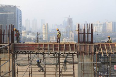 Mumbai Hindistan 'da yüksek binalarda çalışan inşaat işçileri.  
