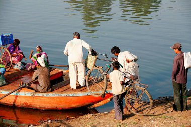 Haripur köyünün köylüleri bisikletlerini bir tekneye yüklüyorlar, Sangli bölgesi, Maharashtra, Hindistan 