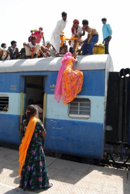 Erkekler kadını tren istasyonunda türbanla sürüklediler. Jodhpur, Rajasthan, Hindistan. 