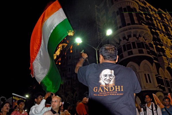 Мужчина в футболке Махатмы Ганди, размахивающий индийским флагом на мирном митинге у отеля Тадж Махал в первую годовщину терактов 26 / 11, Бомбей, Мумбаи, Махараштра, Индия   