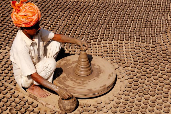 Поттер лепит песок на гончарном круге, Джодхпур, Раджастан, Индия 