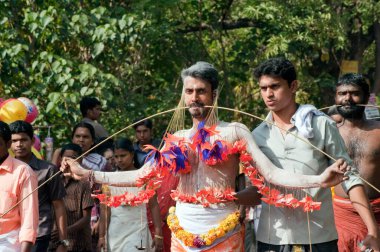 Thaipusam Festivali, Kerala, Hindistan 'da yanaklara piercing yaptıran adam yeminini bozuyor.   