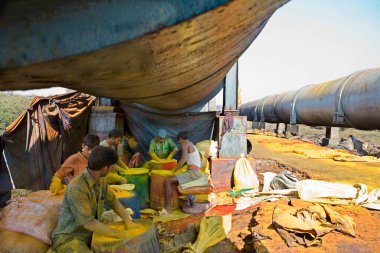 Bombay, Bombay, Maharashtra, Hindistan 'daki endüstriler için renk boyalarını geri dönüştürmek için Güney Mumbai' ye su taşıyan büyük borular Dharavi boştur. 