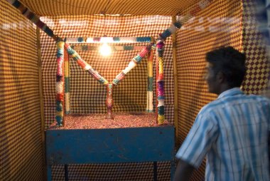 Hindistan 'ın Orissa kentindeki Konarak kasabasında ilüzyonist çırağın çiçek vazosunda kaybolduğu boş tezgahta bir görevli el kol hareketi yapıyor. 