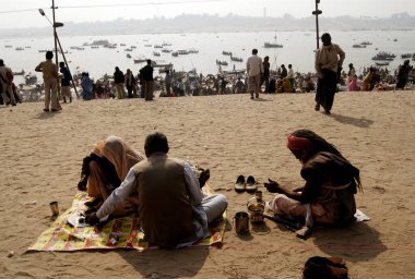 Bir çift, Arkanh Kumbh Mela, Hindistan 'daki efsanevi Saraswati nehirleri olan Ganj, Yamuna' nın kesiştiği yerde yemek yiyor.