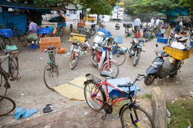 Balık pazarının yakınına park etmiş iki tekerlek ve bisiklet, Koçin, Kerala, Hindistan 