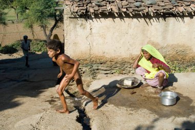 Çocuk yıkanmaya pek hevesli değil. Büyükannesi, Dilwara, Rajasthan, Hindistan... 