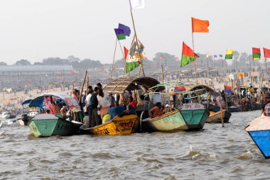 Takipçiler Ganj kavşağına ulaşan teknede oturuyorlar; Ardh Kumbh Mela, Allahabad, Uttar Pradesh, Hindistan boyunca Yamuna ve Saraswati nehirleri birleşiyor. 