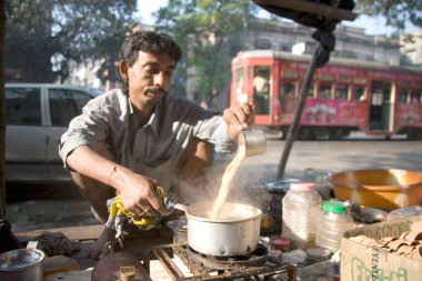 Çaydanlıktan çaydanlığa buhar çayı döken çay satıcısı; Kalküta şimdi Kolkata; Batı Bengal; Hindistan