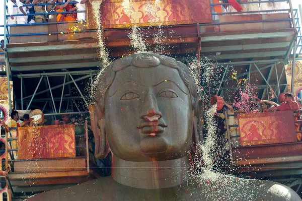 stock image Flowers showering on 57 feet high statue of lord Bahubali known as Gomateshvara in Mahamasthakabisheka celebration at Sravanabelagola in Hassan district of Karnataka, India 