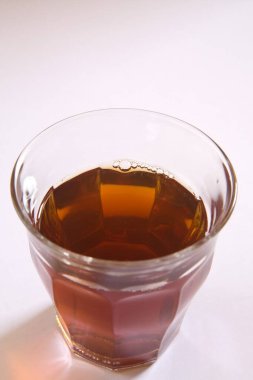 Beyaz arka planda bardakta siyah çay.