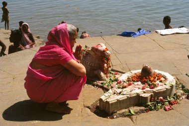 Tanrı 'nın önünde dua eden kadın shiva linga, Hindistan 