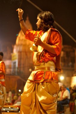Genç rahip Ganga Pooja 'yı Dasasaswamedh ghat' ta sahneleyecek kutsal Ganga nehrinin kıyısında, Varanasi, Uttar Pradesh, Hindistan 