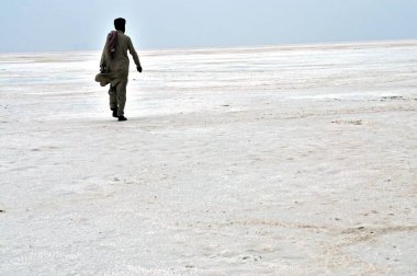 Pathani elbiseli adam çölde tuz kalıntısı üzerinde yürüyor, Bhuj, Kutch, Gujarat, Hindistan