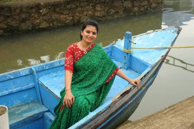 woman sitting in boat, isola di cocco, Kerala, India, Asia clipart