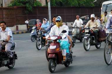 Hindistan 'ın Maharashtra Nagpur şehrinde yaz mevsiminde sıcaktan korunmak için iki tekerlekli bisiklet süren bir kadın kaşkolla yüzünü kapatıyor. 