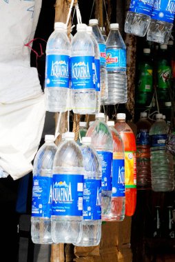 Plastik şişeler dolusu içme suyu ve soğuk içecekler Kanyakumari, Tamil Nadu, Hindistan 'da satılmak üzere dükkanın önünde asılı duruyor. 