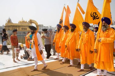 Turuncu renkli Sikh erkekleri Guru Ramdas Jayanti için tören alayını dışarı çıkarırken Akal Takht, Swarn Mandir Altın Tapınağı, Amritsar, Punjab, Hindistan 