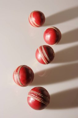 Beyaz arkaplanda beş kriket topu kestane rengi