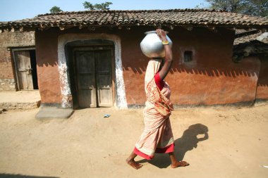 Jharkhand, Hindistan 'da kafasında alüminyum tencereyle su taşıyan bir kadın. 
