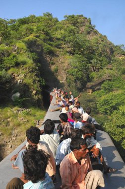 İnsanlar tünelden geçen trenin çatısında seyahat ederken risk alıyorlar; Rajasthan; Hindistan