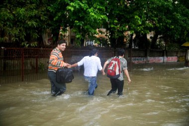 Mevsim musonu; Mumbai 'de 5 Temmuz 2006 tarihli sağanak yağış nedeniyle banliyö yolunda su taşıma; Mumbai Bombay; Maharashtra; Hindistan