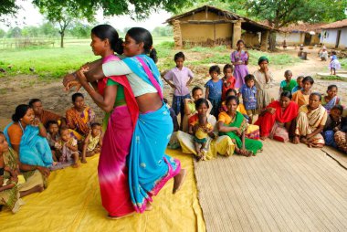 Ho kabilelerinden kadınlar sırtına biniyor ve tıbbi bilgileri paylaşıyorlar, Chakradharpur, Jharkhand, Hindistan  