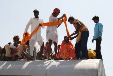 Men successfully dragged woman on roof of train on railway station, Jodhpur, Rajasthan, India  clipart
