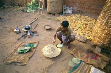 Yeşil yapraklar üzerinde bhutta roti hazırlığı, Jhabua 'nın Bhils' i, Bihar, Hindistan 