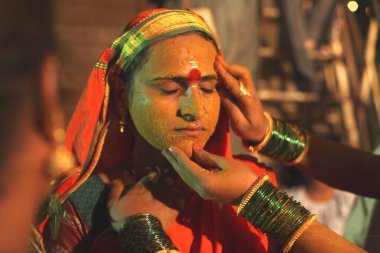 Haldi or turmeric being smeared on face of woman ; wedding of eunuchs on occasion of Bewa Purnima at Ghatkopar ; Bombay now Mumbai ; Maharashtra ; India clipart