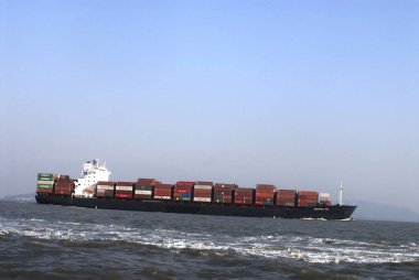 Hindistan, Mumbai Bombay, Maharashtra, Hindistan yakınlarındaki Arap denizinde konteynırla dolu büyük bir kargo gemisi hızla hareket ediyor. 