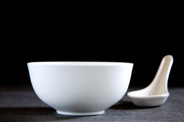 Siyah arka planda yuvarlak şekilli kase ve kaşık