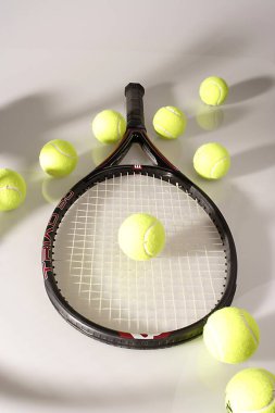 Tenis topları yeşil ve beyaz arka planda bir raket