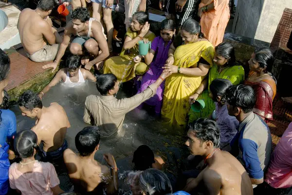 Vajreshwari Thane ilçesi, Maharashtra, Hindistan, Asya yakınlarındaki Ziholi 'de Tripuri Poornima vesilesiyle sıcak suda yıkanan insanlar 