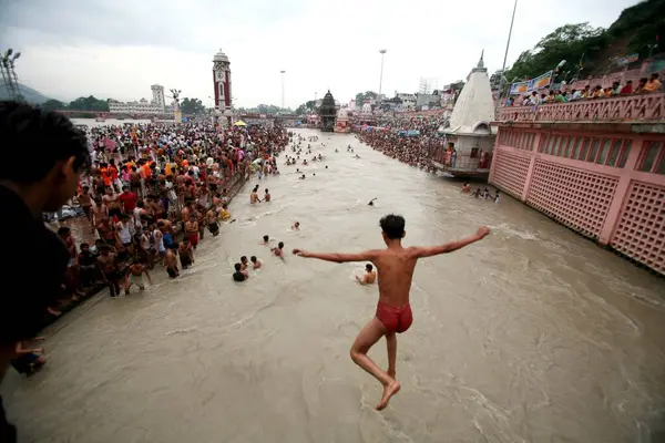 Dindarlar kutsal dalış yapıyor, Har Ki Pauri kelimenin tam anlamıyla Tanrı 'nın ayak sesleri Ganga, Uttaranchal, Hindistan kıyısındaki Haridwar' ın en kutsal Ghat 'ı olarak kabul edilir. 