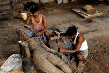 Heykeltraşlar keskiyle bronz simge oydular. 