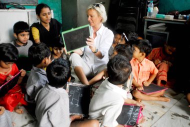 Sabine Christiansen, Amrae 'deki çocuklarla konuşurken Nehru Nagar' daki bir sivil toplum örgütü, Golibar Slum; Santacruz; Bombay Mumbai, Maharashtra, Hindistan   