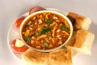 Snacks, misal pav with tomatoes slices served in plate  clipart