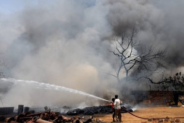 İtfaiyeciler hurda deposu Jodhpur, Rajasthan, Hindistan 'da yangını söndürmeye çalışıyor.