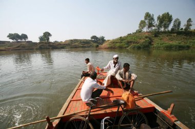 Sangli, Maharashtra, Hindistan 'da Krishna Nehri' ni geçmek için teknenin geçmesini bekleyen Haripur köylüleri.