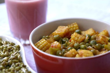 Mixed vegetable of Baby corn , Green peas , tomato and green chilli with Kokam curry , Sol Kadhi in a glass , India clipart