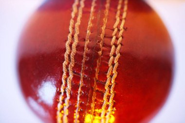 Kırmızı renkli kriket topu dikişi, makro atış.