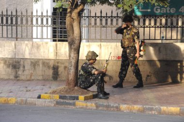 Ulusal Güvenlik Teşkilatı NSG komandosu 26 Kasım 2008 'de Bombay Mumbai' de Deccan Mücahitleri tarafından gerçekleştirilen terörist saldırıdan sonra Oberoi Trident Oteli karşısında yerini aldı.