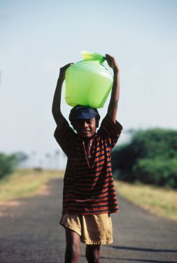 Kırsalda su taşıyan bir çocuk. 