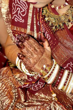 Henna tattoos on bride hand doing namaskaar in marriage ceremony clipart