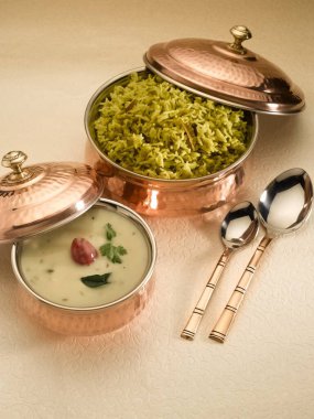 mung dal khichdi with kadhi served in pots clipart