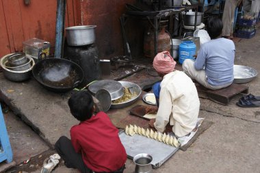 İnsanlar pazar caddesinin karşısında yemek pişiriyorlar, Agra, Uttar Pradesh, Hindistan 
