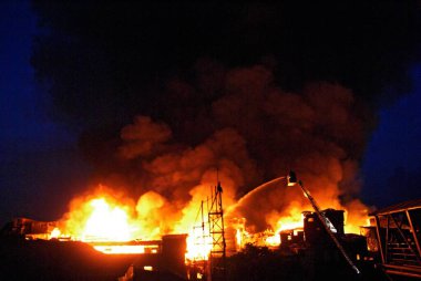 İtfaiyeciler Behrampada gecekondu mahallesinde şnorkel kullanarak yangın söndürüyorlar; Bandra; Bombay Mumbai; Maharashtra; Hindistan 18-Haziran-2009